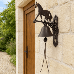 Grande cloche de porte jument et poulain sur façade en pierre
