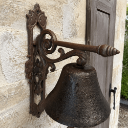 Détail du support à volutes de la cloche de porte rustique