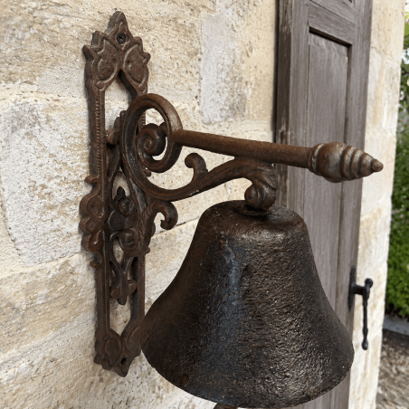 Détail du support à volutes de la cloche de porte rustique