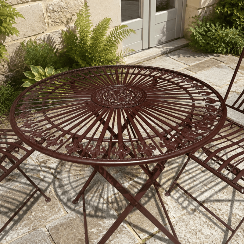 Détail de la table ronde du salon de jardin en métal marron patiné