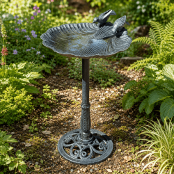 Grand bain d’oiseaux en fonte installé dans un jardin naturel