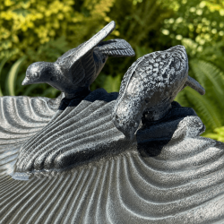 Deux oiseaux décoratifs en fonte posés sur la vasque coquillage