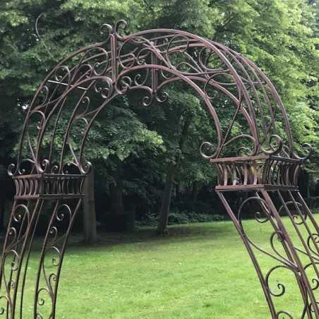 Détail des volutes supérieures de l’arche à rosiers en métal marron patiné