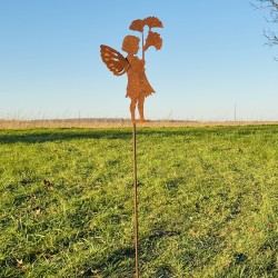 Pique décoratif en métal rouillé avec un personnage féerique installé dans un jardin.