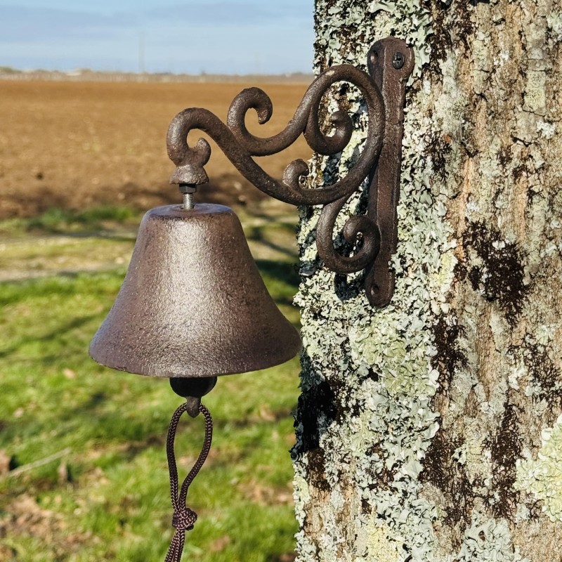 Cloche murale en fonte avec arabesques  vue de face et mise en scène