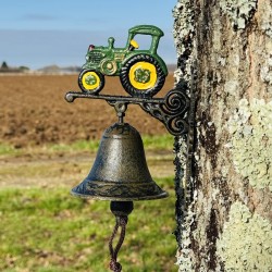 Cloche  de porte murale en fonte avec tracteur mise en scène dans un jardin