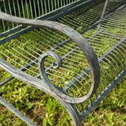 Détail accoudoir ancien sur banc de jardin en métal patiné