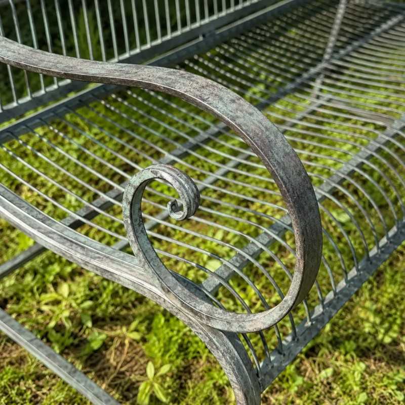 Détail accoudoir ancien sur banc de jardin en métal patiné