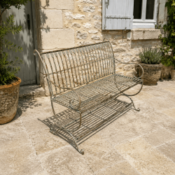 Banc de jardin en métal patiné vert-de-gris rouille sur une terrasse