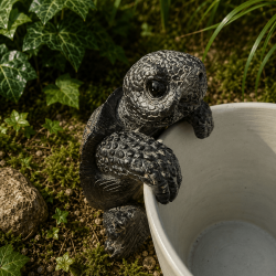Tortue décorative en résine accrochée à un pot de fleurs