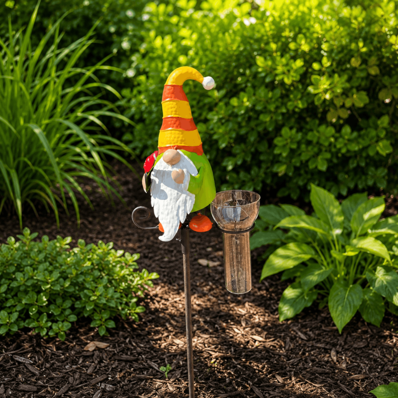 Pluviomètre décoratif nain de jardin sur pic au milieu des plantes